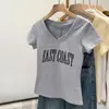 Marca Americana Trendy T-Shirt de Manga Curta com Decote em V no Ombro Direito para Mulheres Verão 2025 Estilo Preppy Estampa de Letras que Reduz a Idade Top Slim