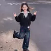 Moda femenina versátil de dos piezas estilo coreano de moda 2026 con un top de bloques de color y jeans, con un lindo colgante de gato