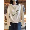 Camiseta feminina de gola V, manga longa, corte slim, acinturada, na cor cáqui, feita de algodão puro, projetada para valorizar a silhueta, para o outono de 2026