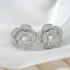 Elegantes aretes florales estilo francés con diseño de camelia tridimensional, base dorada e incrustación densa de circonita, aretes de lujo ligero para mujer al por mayor