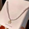 Collar con colgante elegante y delicado de perla rosa para mujer, cadena de clavícula ligera de lujo de alta calidad, joyería estilo Chanel.