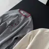 Nuevo cárdigan de punto de estilo coreano a la moda para mujer, cuello redondo, manga larga, corte holgado, efecto adelgazante, top versátil, suéter rojo con bloques de color, 2026