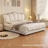 Cama matrimonial tapizada color crema para el dormitorio, con un cabecero en forma de pétalo, creando una atmósfera lujosa y minimalista en la recámara principal.