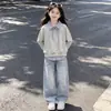 Nueva colección de primavera y otoño para niños de tamaño mediano y grande: un elegante conjunto de dos piezas que presenta un top a rayas con cuello y detalles de patchwork, y pantalones vaqueros con estampado de estrellas