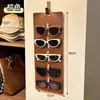 Novo modelo de bolsa de pendurar para armazenamento de óculos para uso doméstico, protetor de óculos de sol de grande capacidade montado na parede, suporte de exibição de óculos de sol de couro vintage