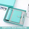 Set de regalo personalizado que incluye un termo, una laptop, una batería externa y un paraguas, con el logotipo de una empresa, adecuado para eventos de negocios y como regalo práctico