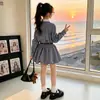 Vestido de Menina para Primavera e Outono 2026 Novo Estilo Menina Doce Estilo Coreano Crianças Médias e Grandes Vestido Camisa Xadrez Flor de Botão
