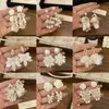 Pendientes de perla de flor blanca explosiva temperamento de alta gama lujo ligero nuevos pendientes de pétalo pendientes delicados venta al por mayor