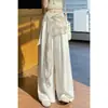 Foto real de elegantes pantalones anchos de capas con accesorios en la cintura para mujer, nuevo lanzamiento de verano 2026, de cintura alta, fluidos, de seda helada, algodón y lino, casuales