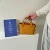 Bolso de mano moderno y sencillo, bolso tipo cubo texturizado, nuevo de la versión coreana para el verano de 2026, bolso de hombro simple y elegante, bolso cruzado