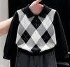 Ropa infantil coreana 2026 colección de otoño nueva: suéter clásico negro con patrón de rombos y cuello, y pantalón de traje gris recto para niños