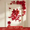 Nueva decoración de habitación de bodas estilo chino, con caracteres auspiciosos, decoraciones festivas para puertas, borlas y arreglos florales, creando un telón de fondo pintoresco para las fotos de boda.