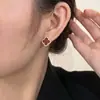 Pendientes pequeños y exquisitos de trébol de cuatro hojas rojos, pendientes de circonita de moda de lujo ligero, pendientes retro para mujer, sentido del diseño de nicho