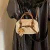 Bolso de mano para mujer estilo commuter, minimalista y sutilmente lujoso para el otoño de 2026, con un diseño afelpado, versátil para llevar al hombro o cruzado.