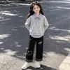 Conjunto de dos piezas para niñas estilo universitario 2026, versátil, con bloques de color a rayas, estampado de gatitos y pantalones casuales