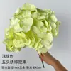 Arranjo floral artificial verde para casamento, com flores artificiais verde-claro, hortênsias, rosas e andorinhas em voo. Ideal para decoração de salão de casamento.