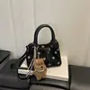 Nuevo bolso cubo de lunares para mujer de principios de otoño 2026, bolso de mano de nicho de lujo ligero de alta gama, bolso cruzado para ir al trabajo, bolsos de mujer al por mayor