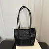 Bolso de hombro tote versátil con patrón hueco tejido de nicho europeo y americano, nuevo de moda otoño 2026