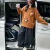 Conjunto outono infantil 2026 novo estilo, suéter de tricô de urso super fofo e calça xadrez conjunto de duas peças para meninas