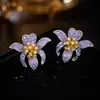 Pendientes de botón de flor francesa cruzada Sentido de diseño de pendientes Nicho Color que preserva el color galvanizado Pendientes de circón Sentido de lujo ligero de alta gama Venta al por mayor