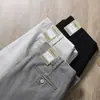Pantalones largos casuales de negocios para hombre, de pierna recta, corte holgado, en color gris, hechos de algodón peinado, con tejido liso grueso y texturizado, y cintura media-alta, adecuados para otoño e invierno