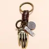 Fábrica directa de accesorios nuevos europeos y americanos, llavero vintage de aleación tejida para hueso de mano, piel de vaca, regalo pequeño simple y creativo