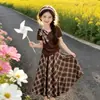 Conjunto de verano estilo coreano para niñas, nuevo conjunto de dos piezas de top con lazo estilo universitario y falda de cuadros, moderno