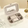 Caja de joyería de cuero estilo lujo con forro de terciopelo, que cuenta con múltiples compartimentos, un espejo y está diseñada para guardar aretes, collares y anillos.