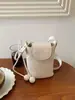 Bolso de axila tejido texturizado para mujer, nuevo modelo 2026, bolso para teléfono de cuero encerado, bolso tipo cubo, bolso cruzado versátil de verano