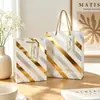 Exquisita bolsa de regalo gruesa de alta gama con lámina dorada y estrellas brillantes, bolsa de compras de marca al por mayor