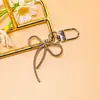 Llavero de lazo de cuentas estilo INS de colores con cinta, colgante de aleación, accesorio para niñas, charm para mochila, accesorio de hebilla para puerta