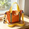 Bolso cubo de mano transfronterizo nuevo, bolso pequeño ligero casual de moda para exteriores, bolso de hombro cruzado versátil con bloques de color para ir al trabajo