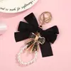 Chaveiro de laço de tecido estilo Ins com strass coloridos, borboleta de metal, pingente de pérola para celular, pingente de decoração para bolsa