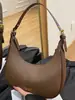 Nuevo modelo de principios de otoño 2026, bolso de media luna simple y elegante, diseño de nicho, color sólido único, sensación relajada, bolso de hombro para llevar debajo del brazo