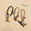 Alça de pulso universal personalizada, alça curta simples multiuso com etiqueta de carinha sorridente, cordão de telefone trançado em blocos de cores retrô