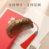 Peine de sándalo negro y dorado con diseño de flor de pera pintada en dorado, peine pequeño de luna de dientes finos con borlas, caja de regalo grabada, caja de regalo souvenir cultural y creativa, peine de madera