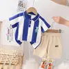 Versión coreana del nuevo conjunto de moda occidental de verano para bebé, camiseta de manga corta con estampado vertical de dibujos animados y pantalones cortos casuales, Directo de Fábrica