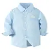 Traje de caballero para niños: camisa de manga larga con cuello azul claro, pantalón largo color blanco roto, juego de tirantes ajustables de color oscuro