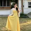 Vestido amarillo de encaje estilo pastoral francés con adornos florales tridimensionales, perfecto para un look juvenil de vacaciones en la playa.
