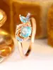 Bestseller transfronterizo: Anillo abierto de zircón azul fresco y elegante, versátil anillo de oro hueco retorcido con zircón azul