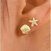 1 par de aretes con temática oceánica que presentan conchas, estrellas de mar y tortugas, en un estilo metálico