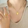 Collar con colgante de corazón de melocotón y cadena de clavícula de acero de titanio y oro de 18 quilates.