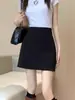 Falda negra de cintura alta para mujer Primavera 2024 Nueva falda corta adelgazante anti-exposición estilo preppy traje de tubo línea A