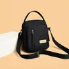 Bolso de hombro y cruzado para mujer de lona de nailon nuevo, bolso pequeño moderno y versátil, bolso para teléfono portátil multicapa, bolso de mano simple