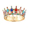 Esta lujosa y elegante corona está diseñada con cristales multicolores incluyendo gemas rojas verdes azules y moradas engastadas en una hermosa base de aleación dorada Ideal para novias concursos y eventos formales ofreciendo un toque perfecto de elegancia real