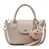 Otoño 2026 Nuevo Bolso Cuadrado Pequeño con Patrón de Lichi Estilo Coreano para Mujer Bolso Cruzado Versátil Bolso de Hombro para Viaje con Colgante de Oso de Peluche