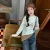 Camiseta de manga larga para niña con estampado de cachorro de dibujos animados, nuevo estilo de principios de otoño 2026, moderna y casual para niños