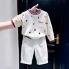Suéter de punto de estilo coreano para niños, nuevo de otoño 2026, con estampado de dibujos animados, letras, bloques de color, y pantalones casuales blancos para niños