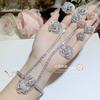 Pulsera y anillo con incrustaciones de circonitas y flores bañadas en oro de 18 quilates estilo Chanel.