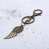 Chaveiro de folha de liga de metal direto da fábrica, chaveiro de pena, bolsa de presente pequena criativa, pingente para meninas, joia pequena